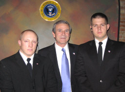 Brent Mendenhall as "George W." with security personnel.